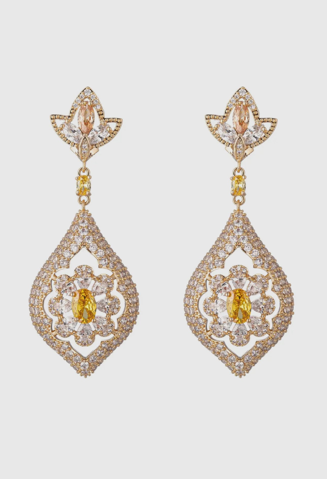 Pair of gold and diamond earrings on a light gray background