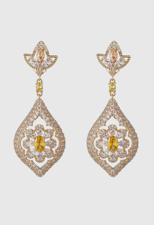 Pair of gold and diamond earrings on a light gray background