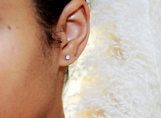 single diamond stud earring on left of of model